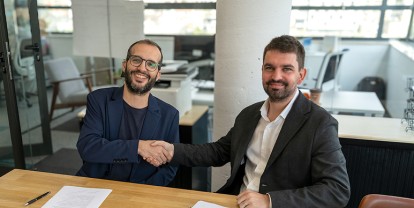 Pau Farré y Àlex Casero dándose la mano durante la firma del acuerdo