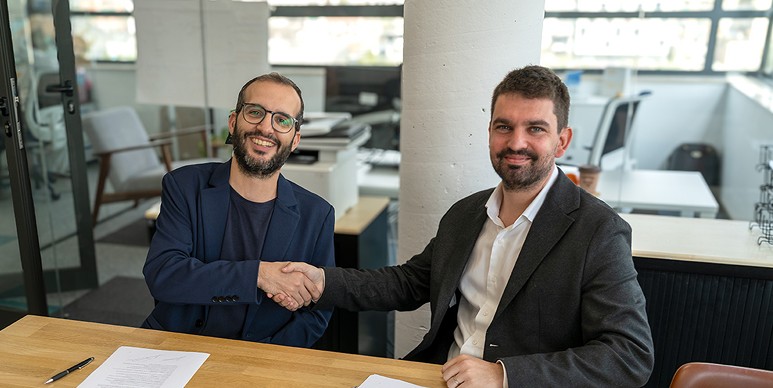 Pau Farré y Àlex Casero dándose la mano durante la firma del acuerdo